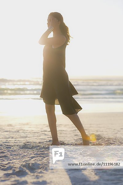 Attraktive junge Frau beim Spaziergang am Strand