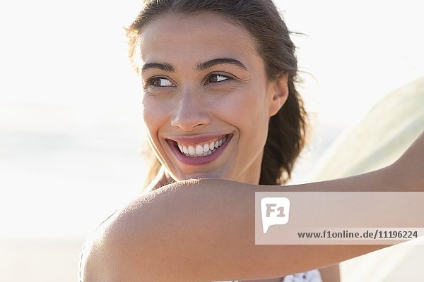 Attraktive junge Frau lächelnd am Strand