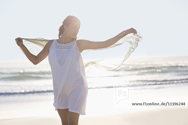 Attraktive junge Frau genießt am Strand