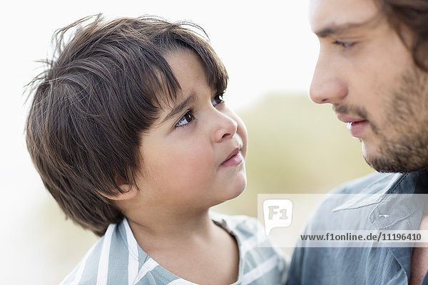 Close-up of a man and his son looking at each other