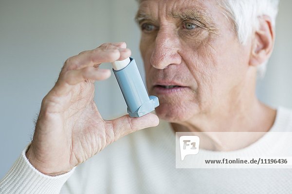 Nahaufnahme eines älteren Mannes mit Inhalator