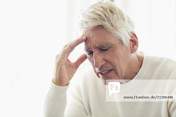 Älterer Mann mit Kopfschmerzen