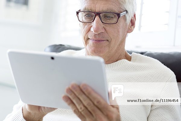 Älterer Mann mit einem digitalen Tablett
