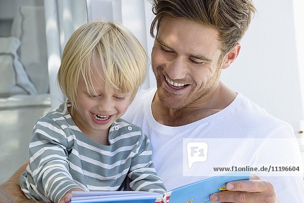 Glücklicher Vater und Sohn beim Lesen eines Buches