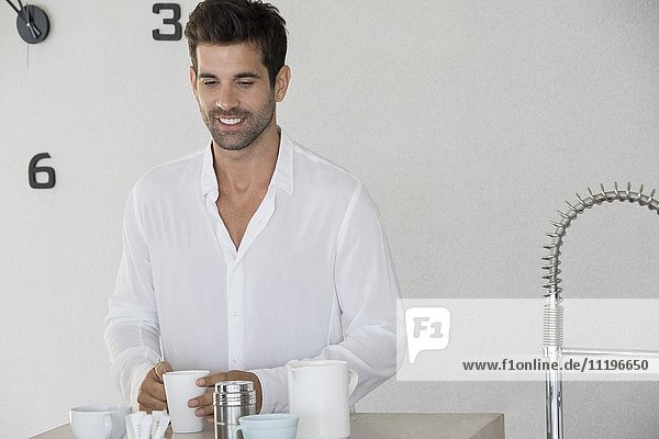Glücklicher Mann genießt eine Tasse Kaffee zu Hause