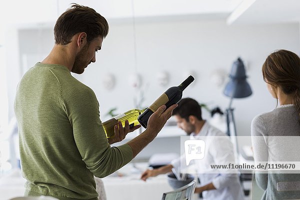 Close-up of a man checking a wine bottle