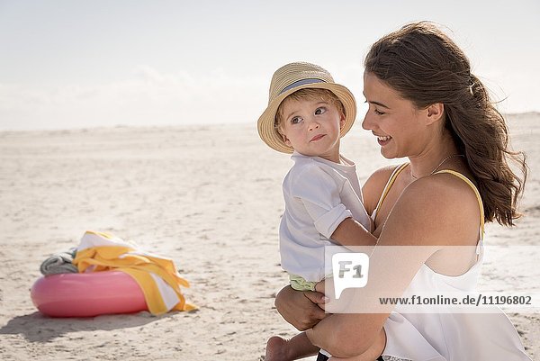 Glückliche Mutter mit ihrem kleinen Sohn am Strand
