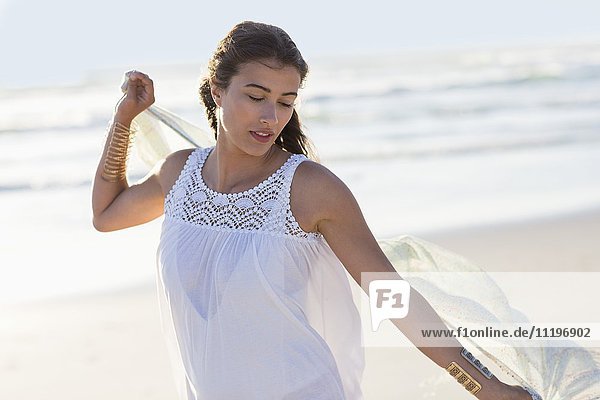 Schöne junge Frau genießt am Strand