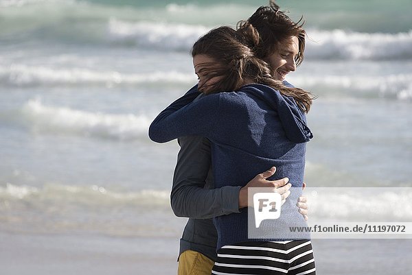 Ein Paar  das sich am Strand umarmt.