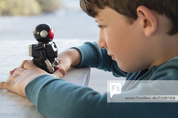 Close-up of a boy playing with toy robot