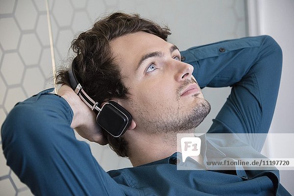 Junger Mann hört Musik mit Kopfhörern
