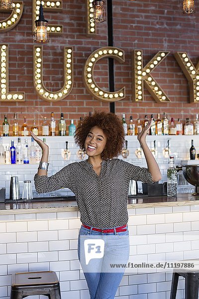 Portrait of happy young woman having fun at bar counter