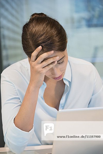 Stress Geschäftsfrau sitzt vor einem Laptop