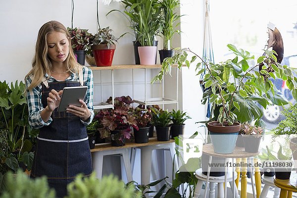 Woman using a digital tablet at her flower shop
