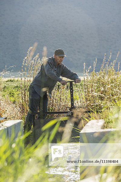Kaukasischer Landwirt beim Einstellen der Bewässerungsanlage