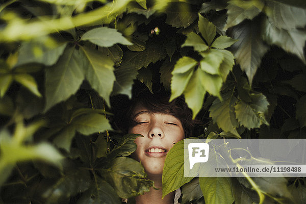 Caucasian boy smiling in leaves
