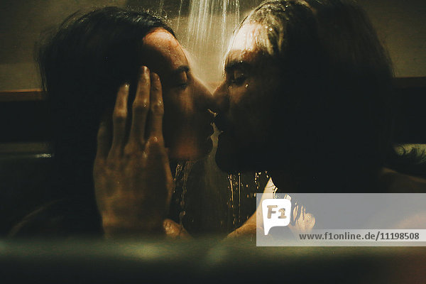 Kaukasisches Paar entspannt sich in der Badewanne unter der Dusche