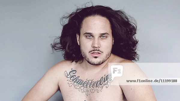 Tattooed Man with Long Hair Blowing in Wind