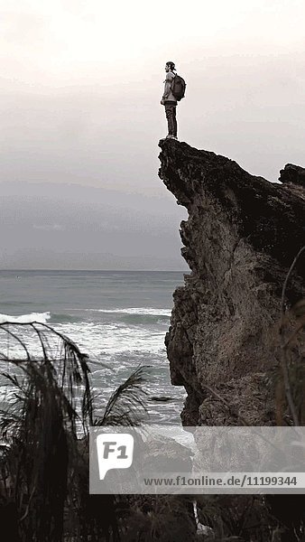 Man Standing on Ocean Cliff