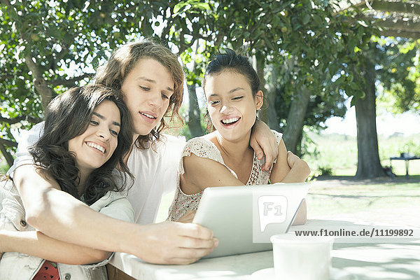 Junge Freunde beim gemeinsamen Anschauen von Videos auf einem digitalen Tablett