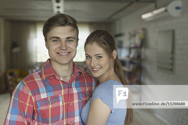 Portrait of smiling young couple standing at home