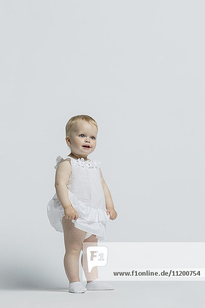 Girl wearing dress standing against white background