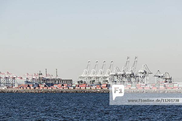 Sea and commercial dock against clear sky