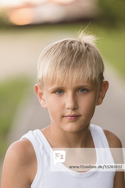 Portrait of confident boy with gray eyes standing at park