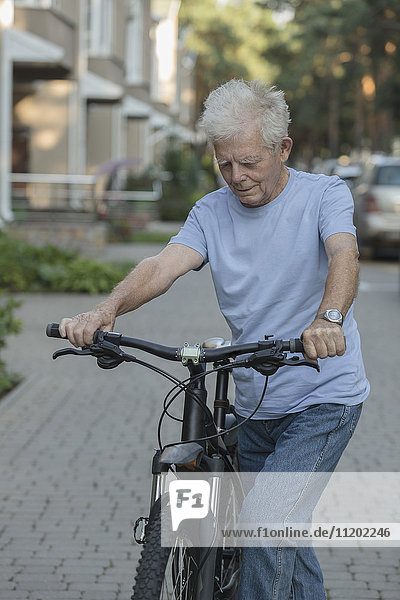 Seniorenradfahren auf der Kopfsteinpflasterstraße in der Stadt