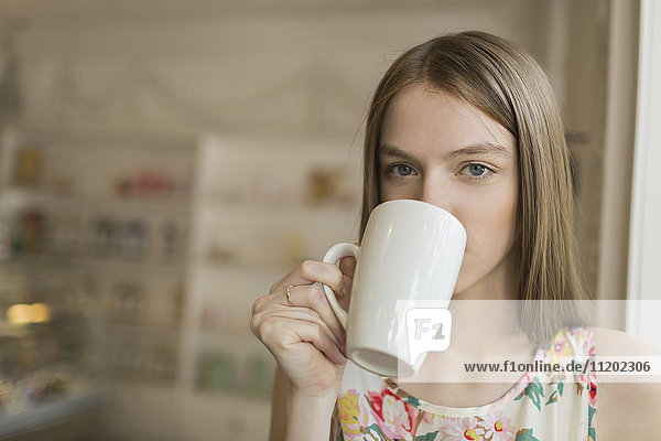 Porträt einer schönen Frau beim Kaffeetrinken im Café