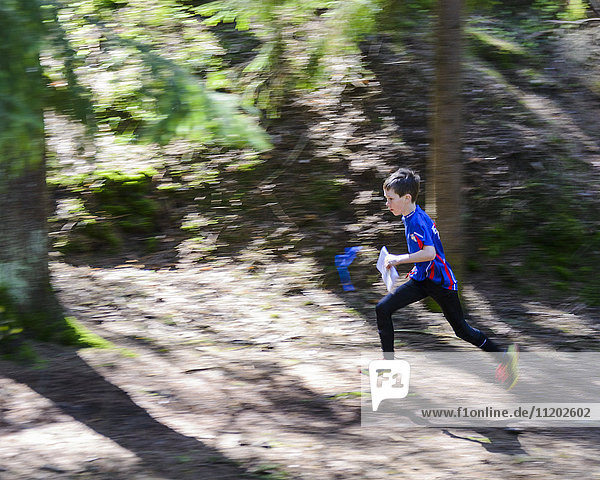 Boy running through forest