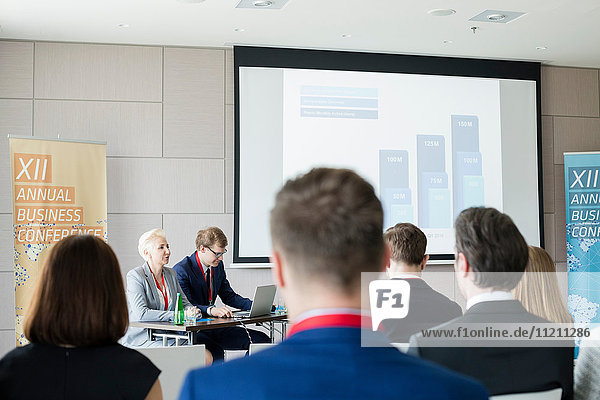 Business people sitting in seminar hall at convention center