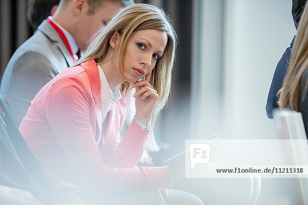 Portrait of confident businesswoman sitting in seminar hall