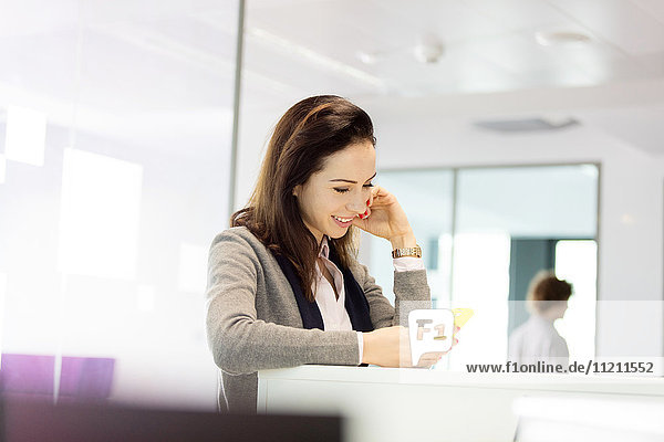 Young businesswoman using mobile phone in office