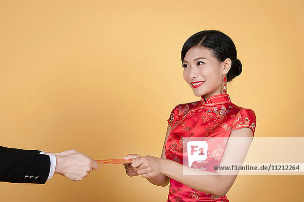 hübsche chinesische junge Frau erhält rote Tasche für glückliches chinesisches Neujahr