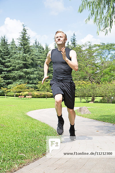 Fit und gesund kaukasischer Mann läuft im Park