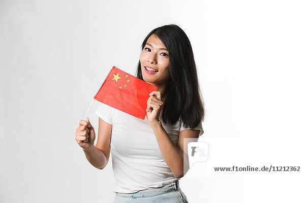 Chinese woman holding up a Chinese flag against white background