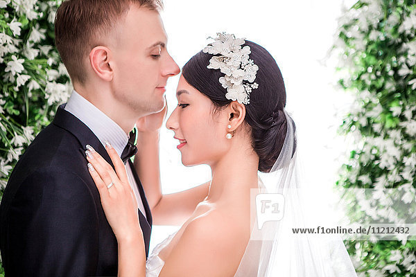 Side view of romantic multi-ethnic wedding couple