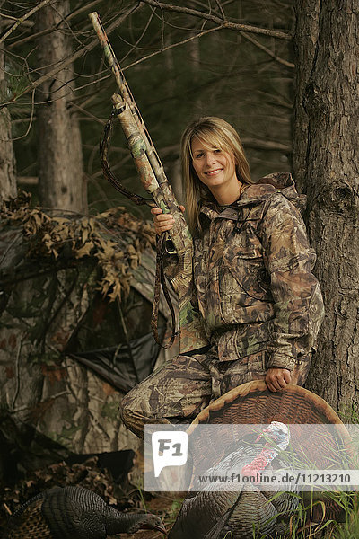 Female Turkey Hunter With Shotgun In A Turkey Blind