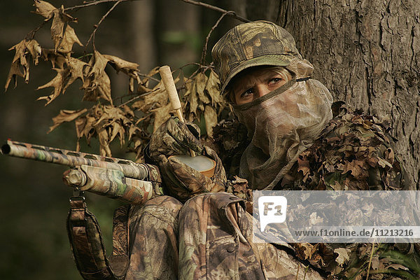Female Turkey Hunter With Shotgun In A Turkey Blind