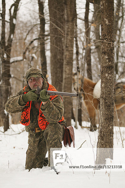 Vorderladerjäger mit Pferd auf der Jagd im Winter