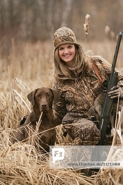 Female Waterfowl Hunter With Rifle And Rusty Yellow Lab