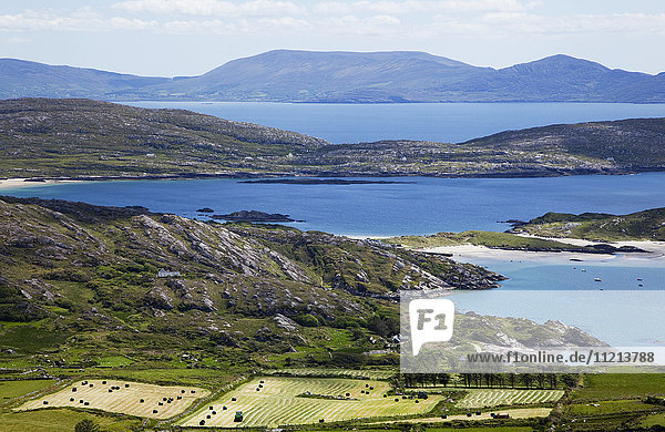 'Farmland in the foreground and mountains across the ocean in the distance; Caherdaniel County Kerry Ireland'