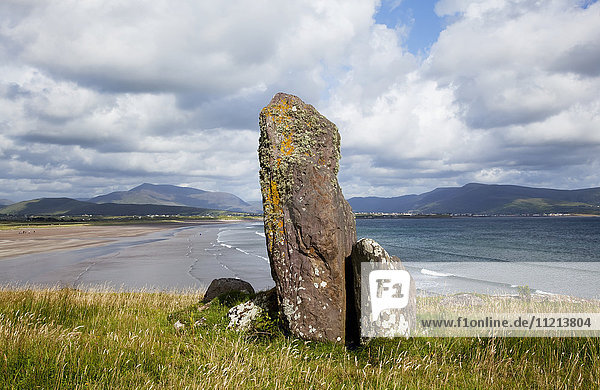 'An ancient standing stone on a ridge overlooking the ocean and coastline near Waterville; County Kerry Ireland '