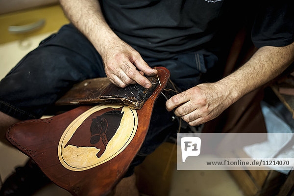 Die Hände eines Handwerkers bei der Bearbeitung von Leder; Pelotas  Rio Grande do Sul  Brasilien'.