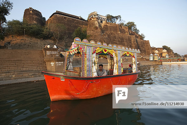Pleasure boat on the Namada River in front of Ahilya fort  Meheshwar  India
