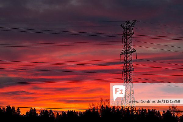 Silhouette eines hohen Metall-Elektroturms mit buntem  dramatischem Himmel bei Sonnenaufgang; Calgary  Alberta  Kanada'.