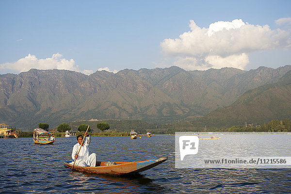 Handwerker paddeln mit Kanu und Shikaras auf dem Dal-See
