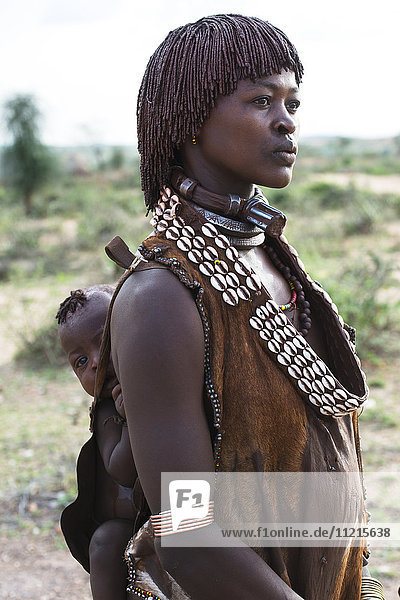 Frau vom Stamm der Hamar trägt Baby auf dem Rücken; Äthiopien'.
