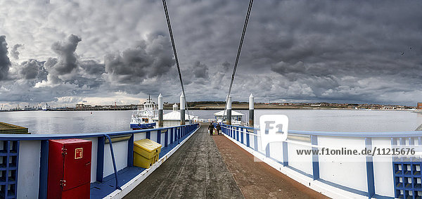 Menschen  die auf einem Pier auf das Wasser und den Hafen hinausgehen; South Shields  Tyne and Wear  England'.